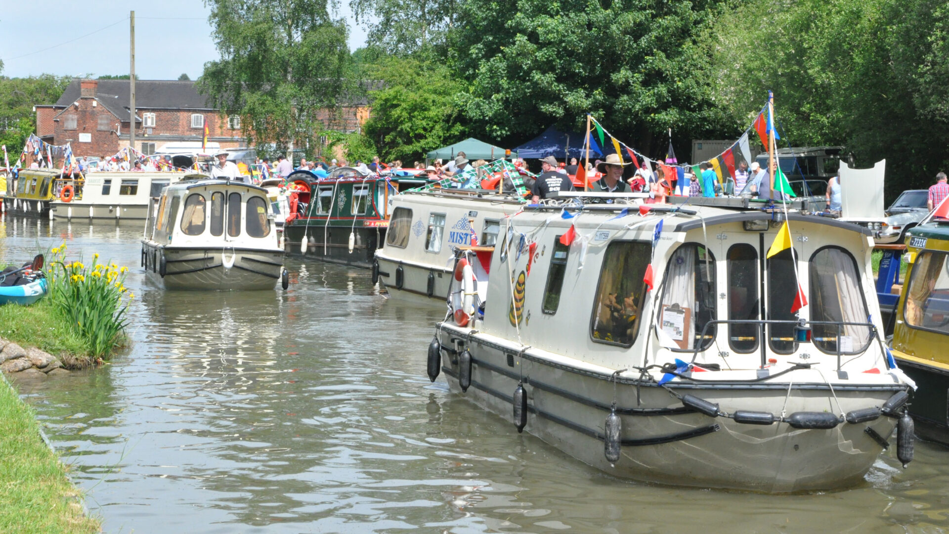 trailboats with bunting cruising along the canal