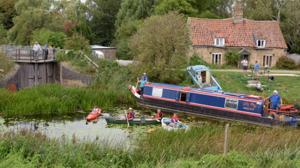 a narrowboat and canoes rally by the closed Welches Dam Lock