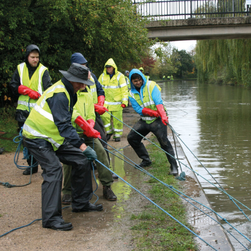 Volunteers in hi viz jackets pulling rubbish out of the canal