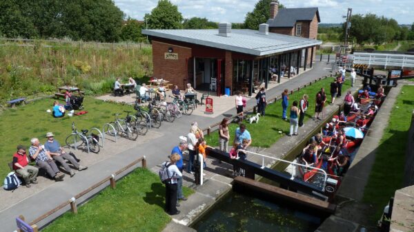 Canoeists in a lock with building and people around