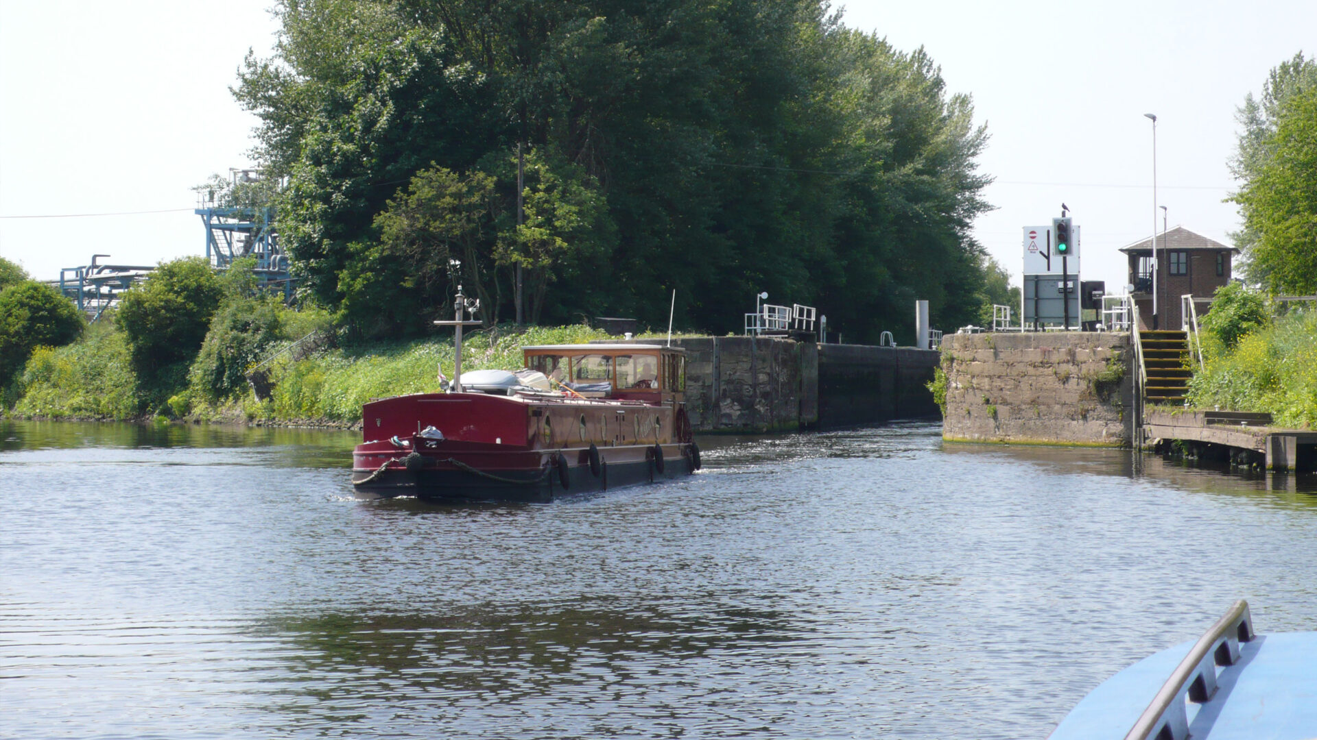 wide beam boat leaving a river lock