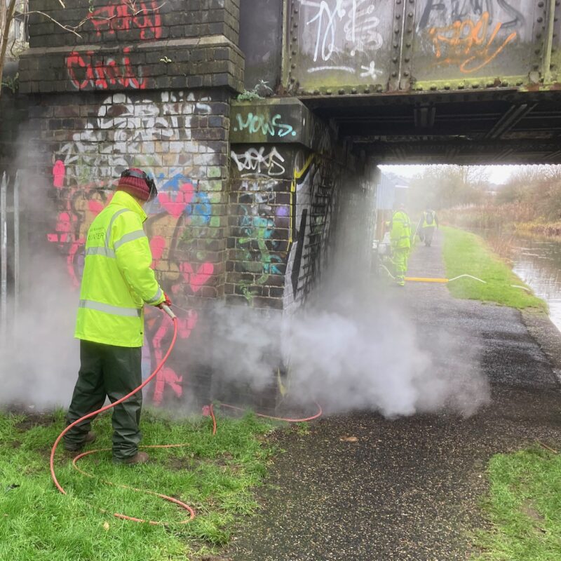 Graffiti being removed with super-heated water cleaning equipment