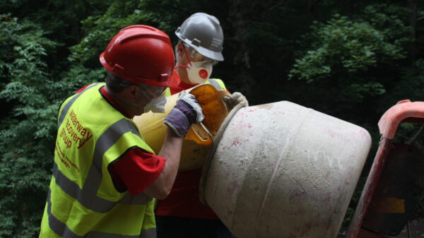 Volunteers mixing mortar wearing dust masks