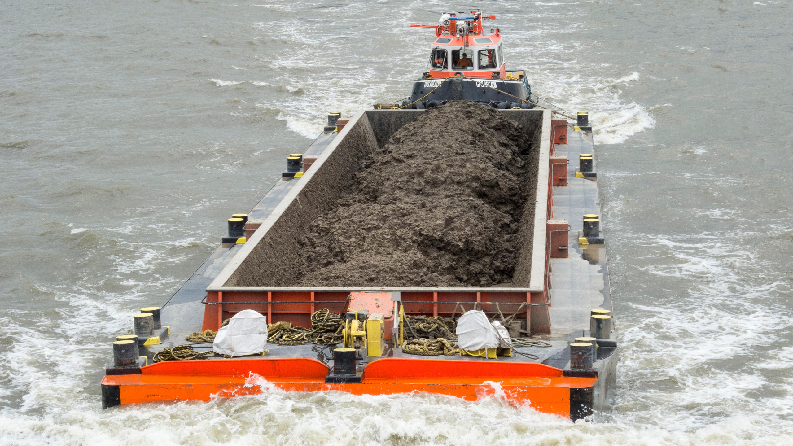 HVO-fuelled GPS Arcadia with a loaded barge on the Thames tideway