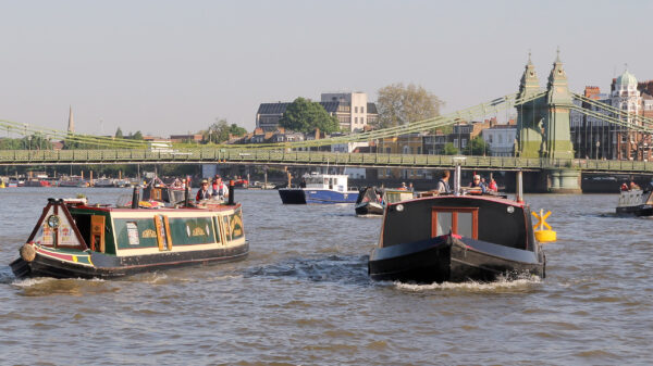 Hammersmith Bridge with boats underneath
