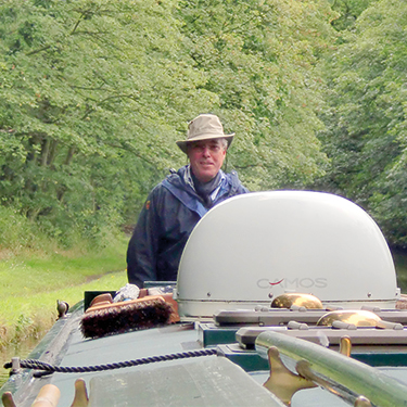 Sir Robert Atkins steering a boat