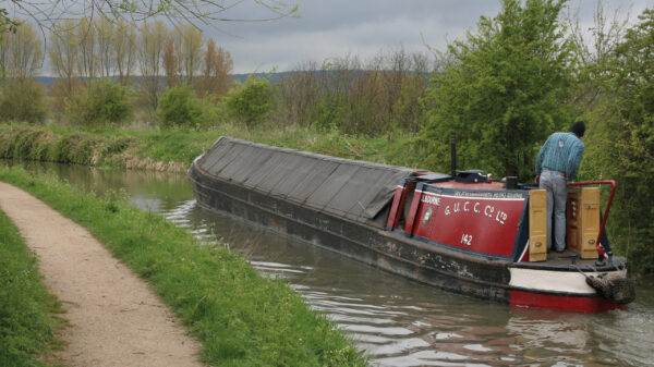 A boat cruising at Wendover Arm on the Grand Union Canal.