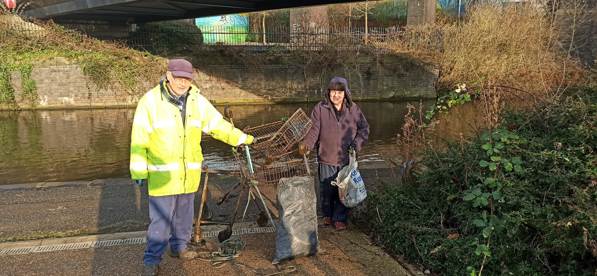 two volunteers with shopping trollies that have been removed from the canal