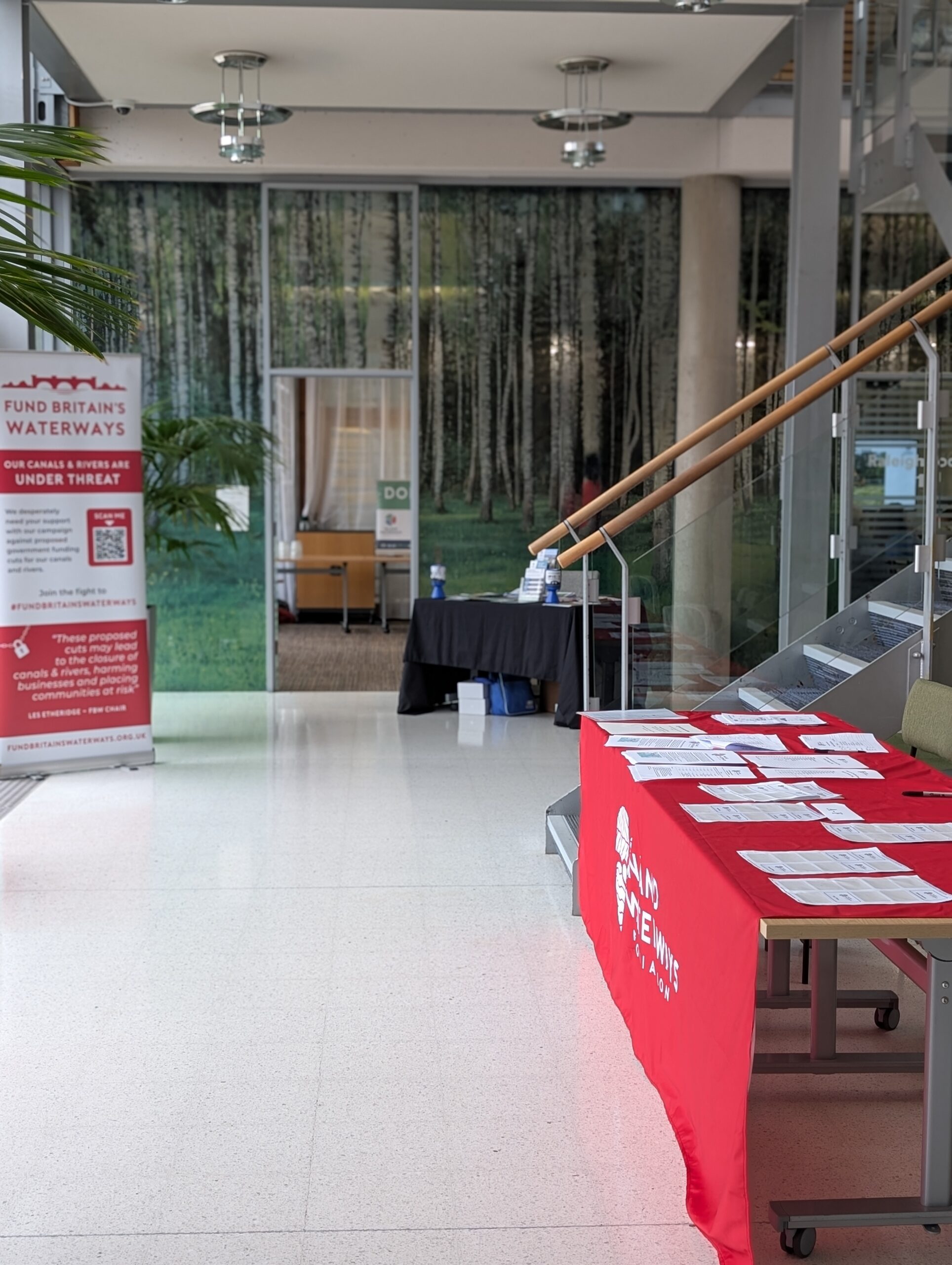 A foyer with an IWA banner and a table with red table cloth featuring the IWA logo.