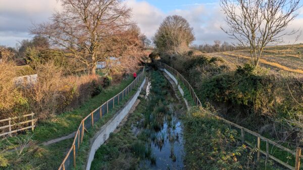 The image shows a drained Wendover Arm (the section under restoration) fenced off and with vegetation growing in the canal bed